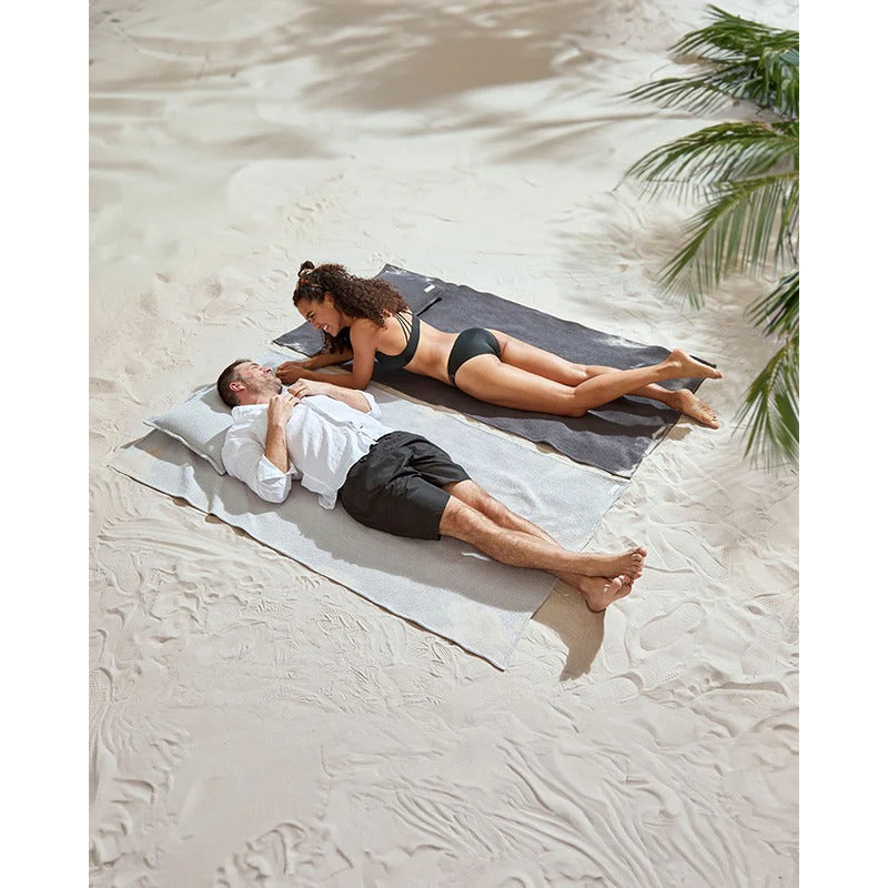 Zwei Personen genießen das Badesofa Strandsofa am Strand – Komfort trifft auf Design und Funktionalität.